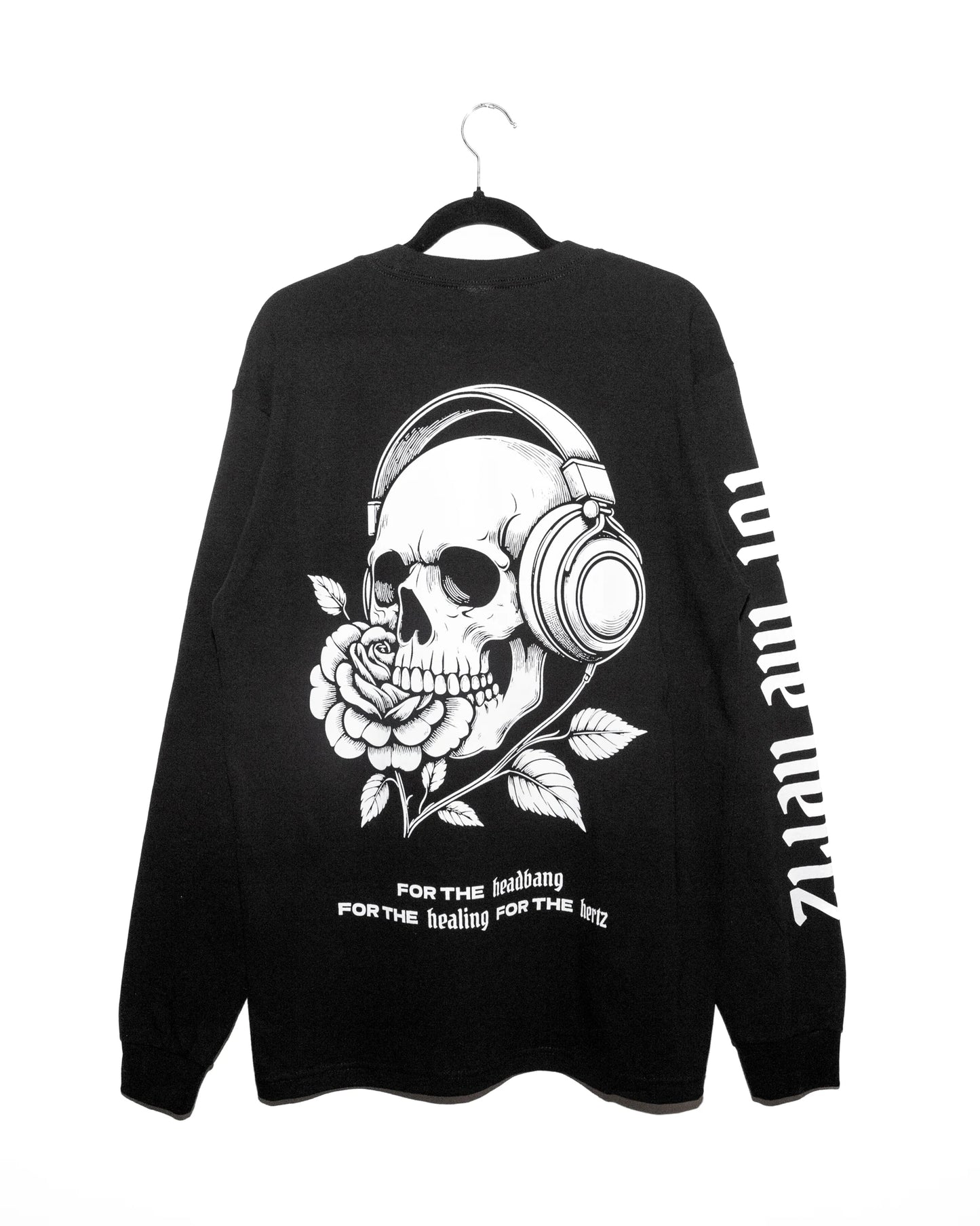 black long sleeve oversized tshirt with skull wearing headphones with cords that turn into a flower on a hanger