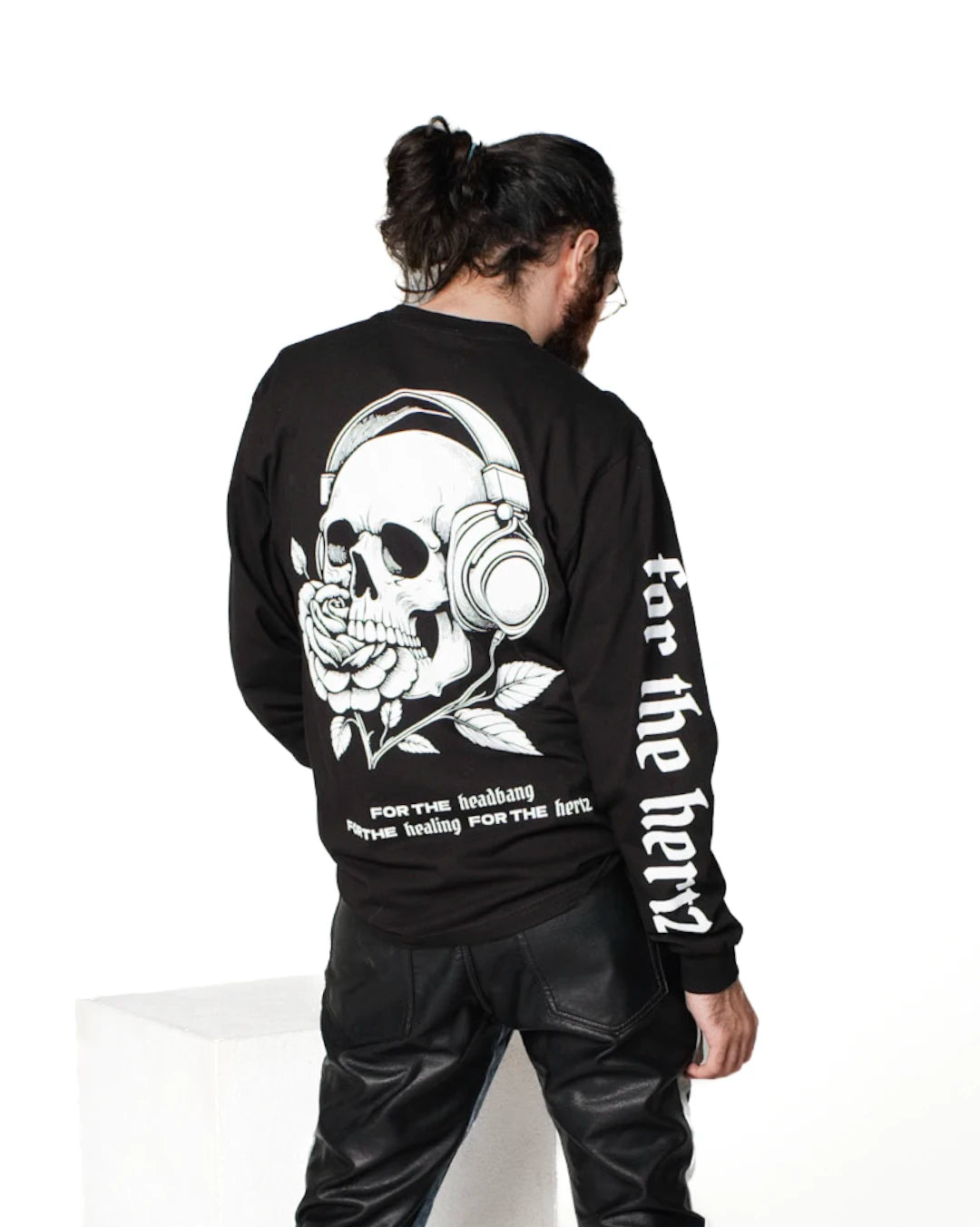 Person wearing skull long sleeve black t-shirt with black leather pants